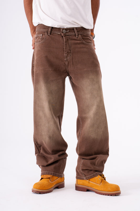 Brown baggy jeans worn by a person on a white background