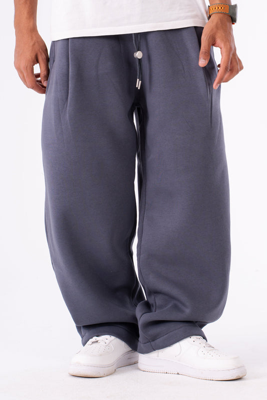 Person wearing gray baggy sweatpants on a white background