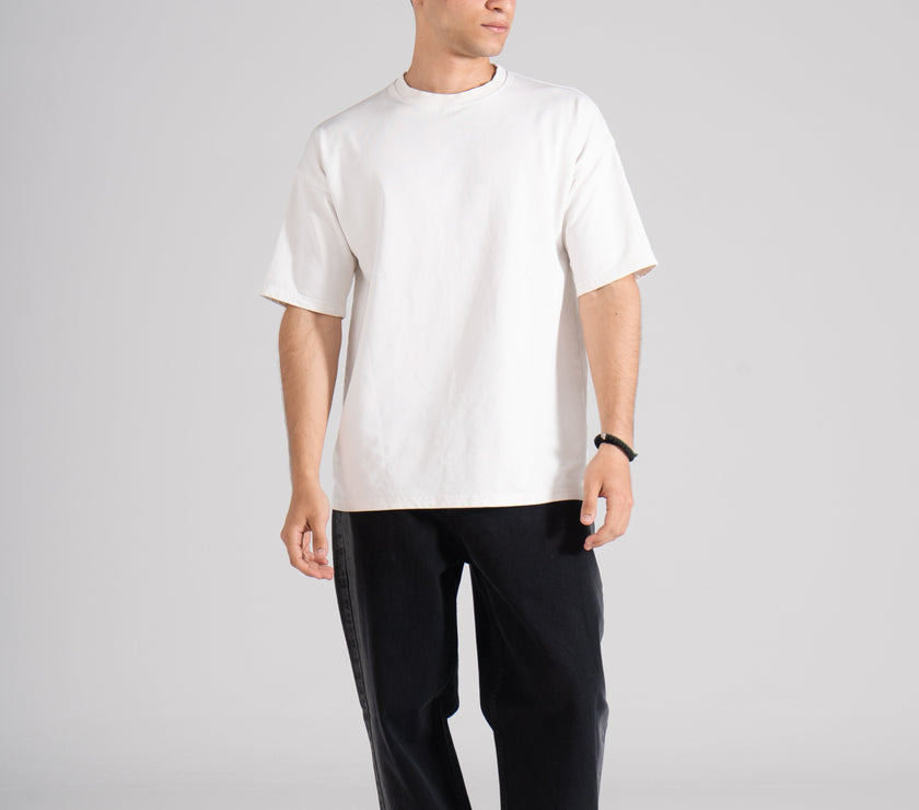  A man dressed in a white t-shirt paired with stylish black denim pants.