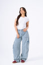 Woman wearing light blue cargo pants and a white t-shirt on a white background