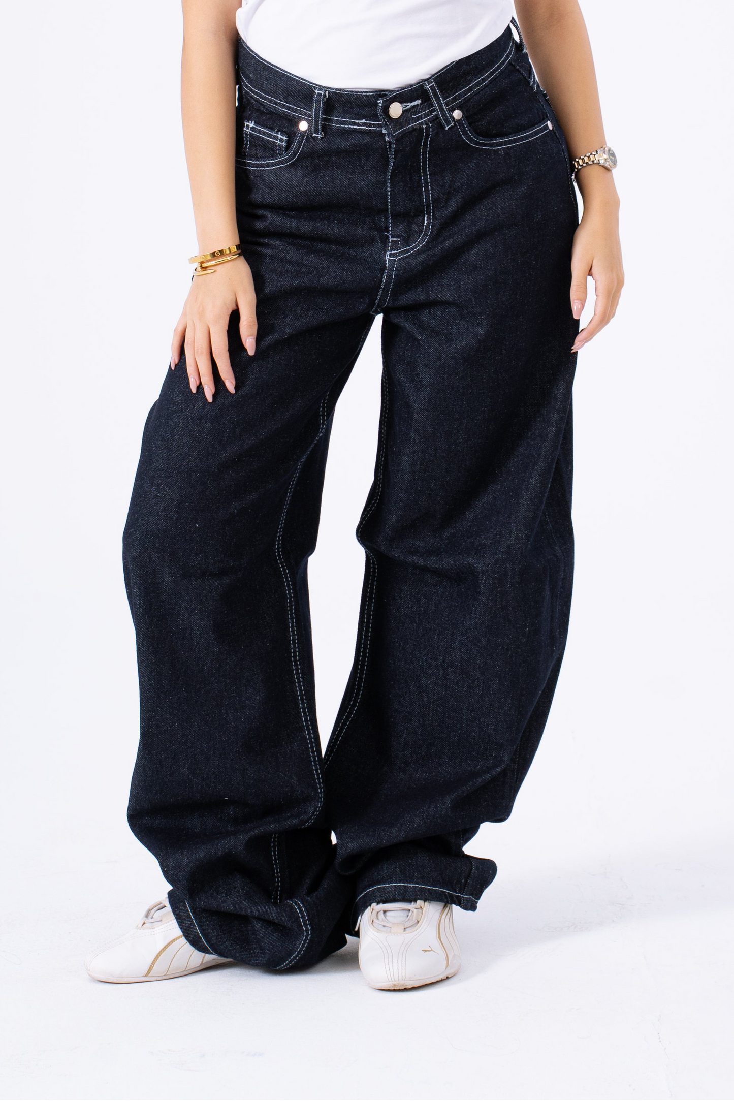 Person wearing baggy dark blue jeans on a white background