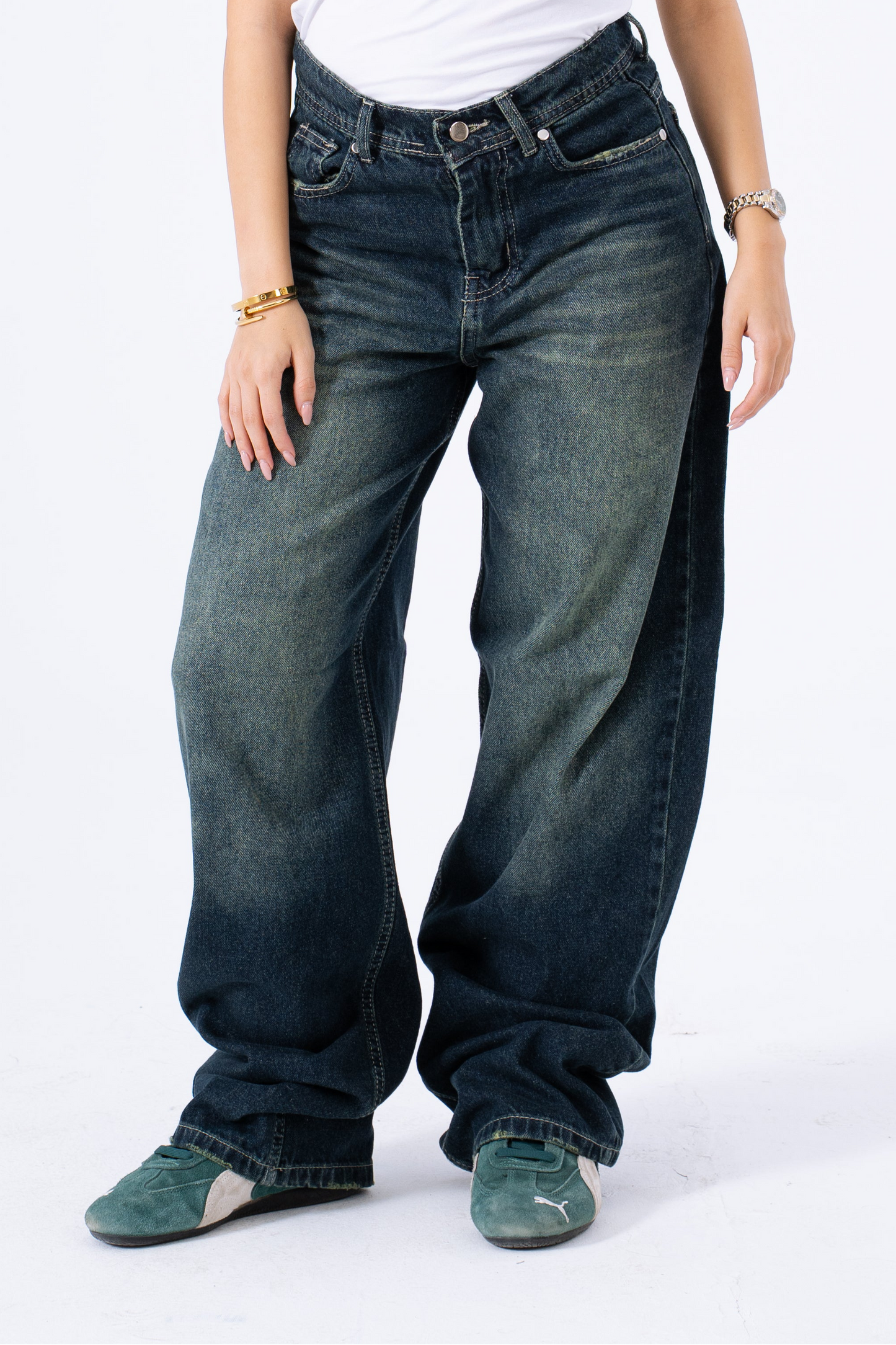 Person wearing greenish baggy jeans on a white background