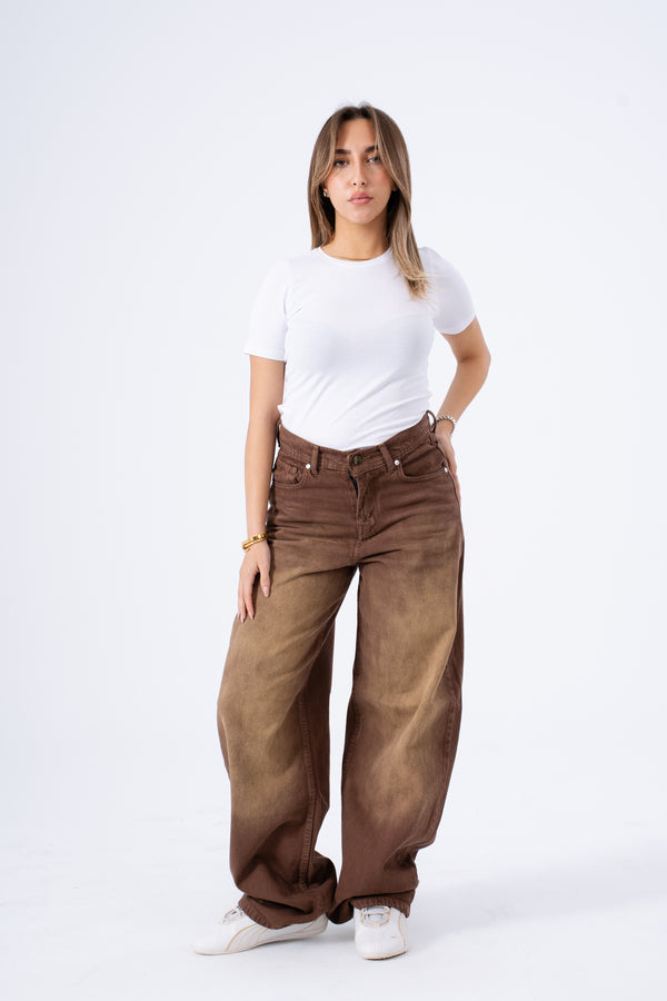 Woman wearing brown wide-leg jeans and a white t-shirt on a white background