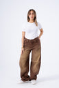 Woman wearing brown wide-leg jeans and a white t-shirt on a white background
