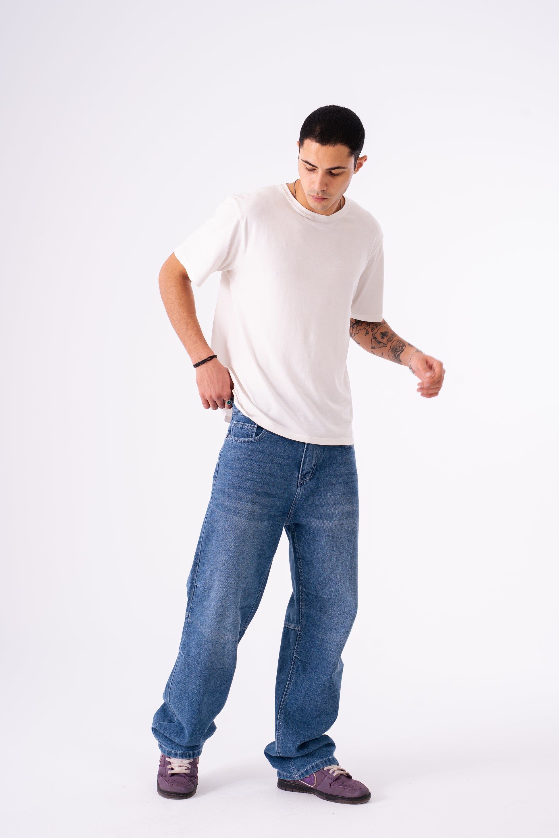 Man wearing a white t-shirt and blue jeans on a white background