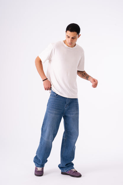Man wearing a white t-shirt and blue jeans on a white background